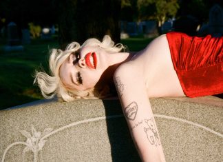 Glüme: “A lot of people who go through childhood abuse are expected to lie about it” Glüme on a headstone in a red dress